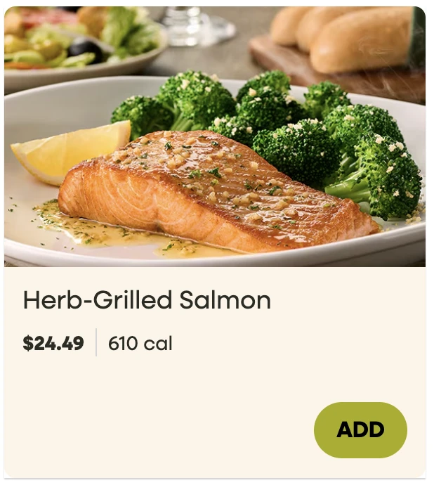 Olive Garden Herb-Grilled Salmon with broccoli and a lemon wedge, shown on Olive Garden’s online menu at 610 calories